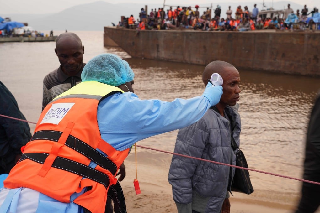 A member of staff from the International Organization for Migration takes the temperature of a passenger from an intercepted boat outside Kinshasa, the capital of the Democratic Republic of Congo, on Thursday. Photo: Xinhua