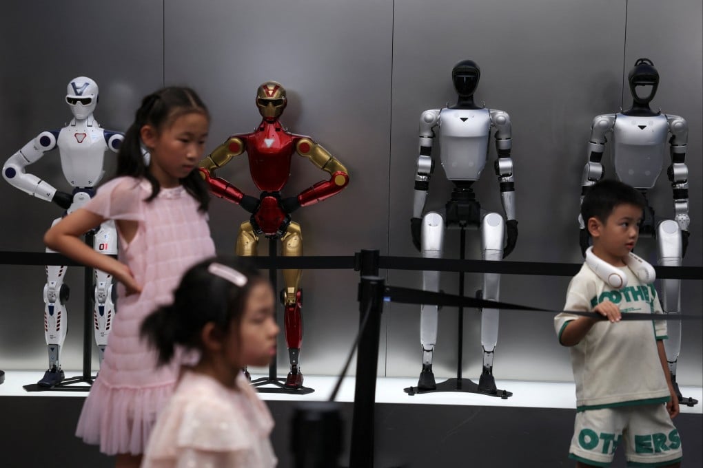 Children stand near Unitree robots on display at a store in Beijing on Monday. Photo: Reuters