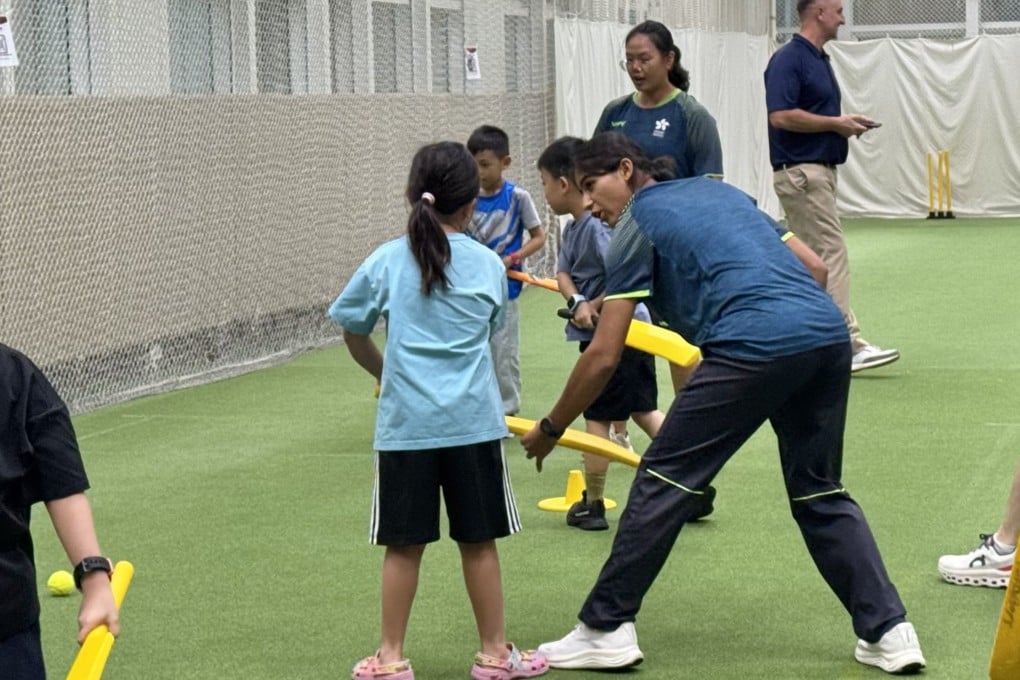 Hong Kong women’s vice-captain Maryam Bibi (right) coaches a child during a cricket activity at Sports For All Day. Photo: Veronica Qi