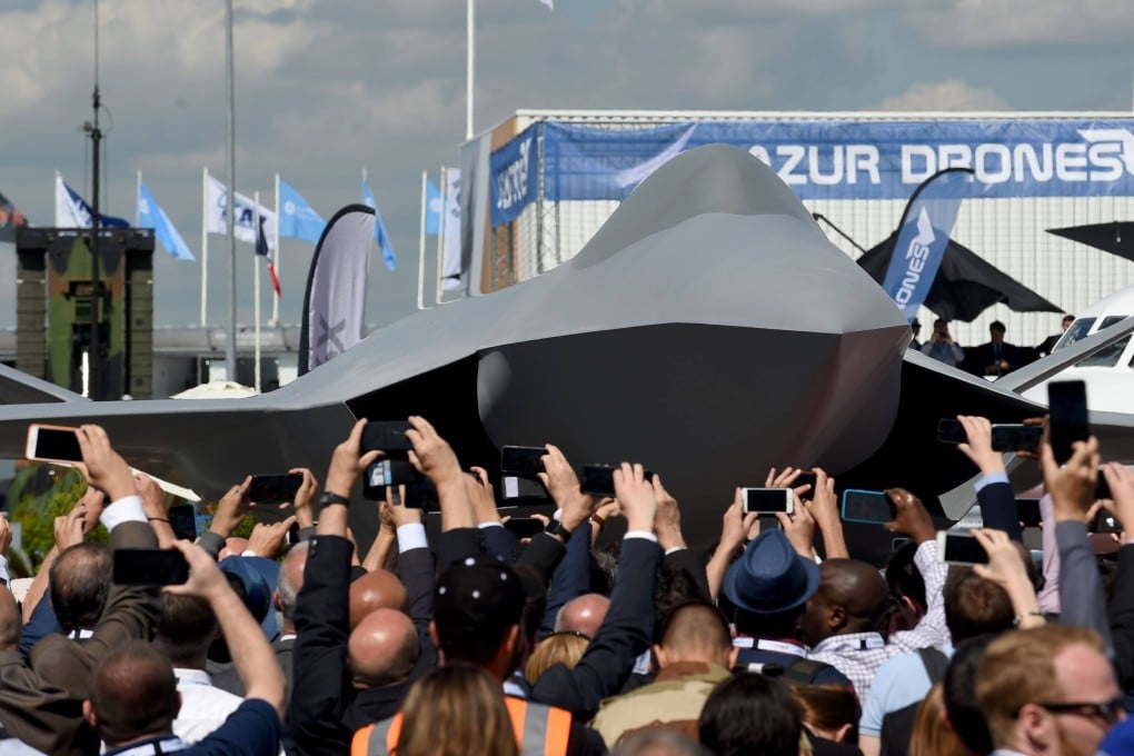 Visitors watch the unveiling ceremony of the full-scale jet fighter model of the Systeme de Combat Aerien Futur, the French-German-Spanish next-generation Future Combat Air System (FCAS) at an air show near Paris in June 2019. Photo: AFP
