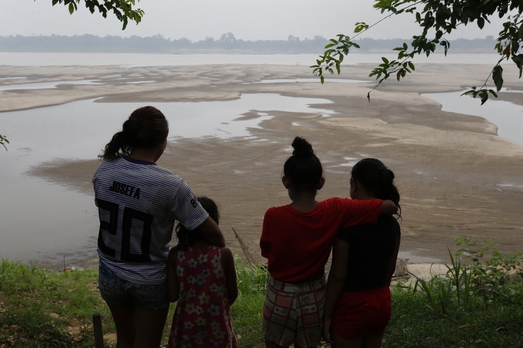 Residents look out at the Madeira River, a tributary of the Amazon River amid a drought in Humaita, Amazonas state. Brazil has teamed up with China to create a geostationary satellite that can predict extreme weather events. Photo: AP