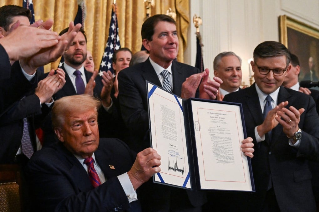 US President Donald Trump holds the signed Genius Act, which will develop a regulatory framework for stablecoins, at the White House on July 18, 2025. Photo: Reuters