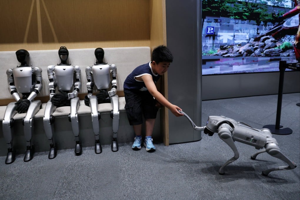 Unitree’s G1 humanoid robots sit next to a child interacting with the company's GO2 robot at a Unitree store in Beijing on August 1, 2026. Photo: Reuters