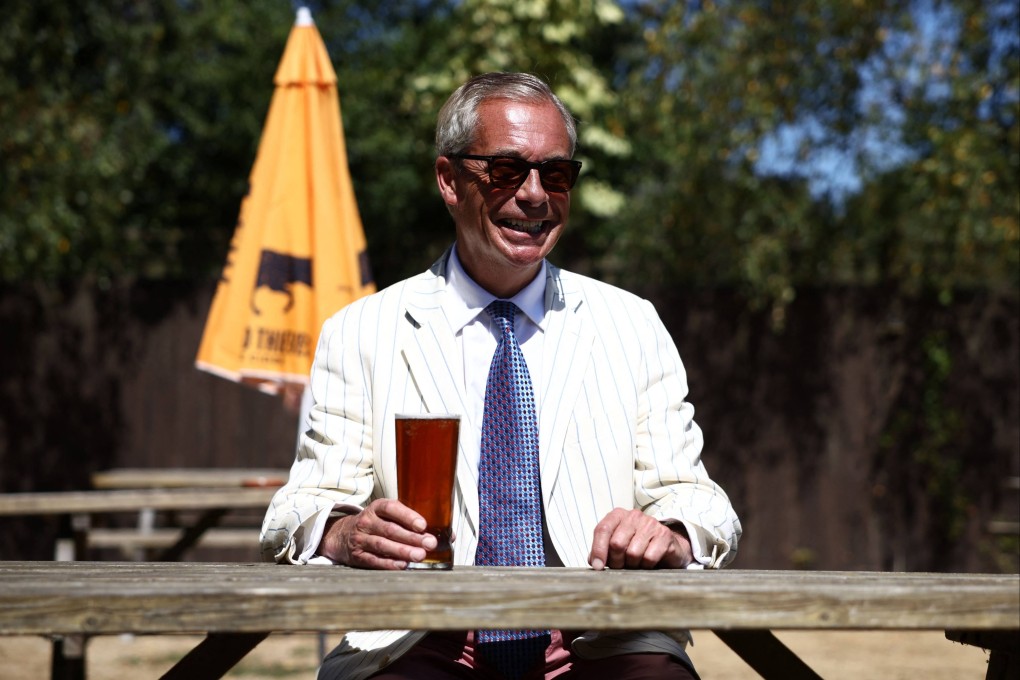 Reform UK leader Nigel Farage sits with a pint in the garden of The Ship pub after casting his vote in the Clacton by-election earlier in the morning, in the village of Kirby-le-Soken, Essex on Tuesday. Photo: AFP
