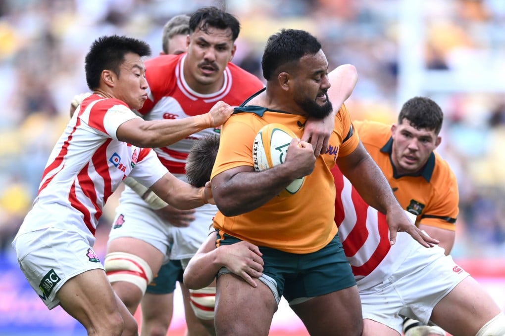 Taniela Tupou of Australia tries to fend off Japan’s players in the rugby Test match between the two sides in Townsville, Australia. Photo: EPA