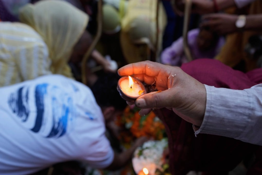 A Hindu devotee lights an earthen lamp during the holy month of Sawan at a  temple in Jammu, India, on August 10. Photo: AP