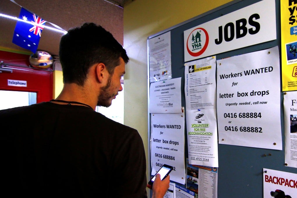 A man looks at job ads posted on a notice board at a backpacker hostel in Sydney,. Photo: Reuters