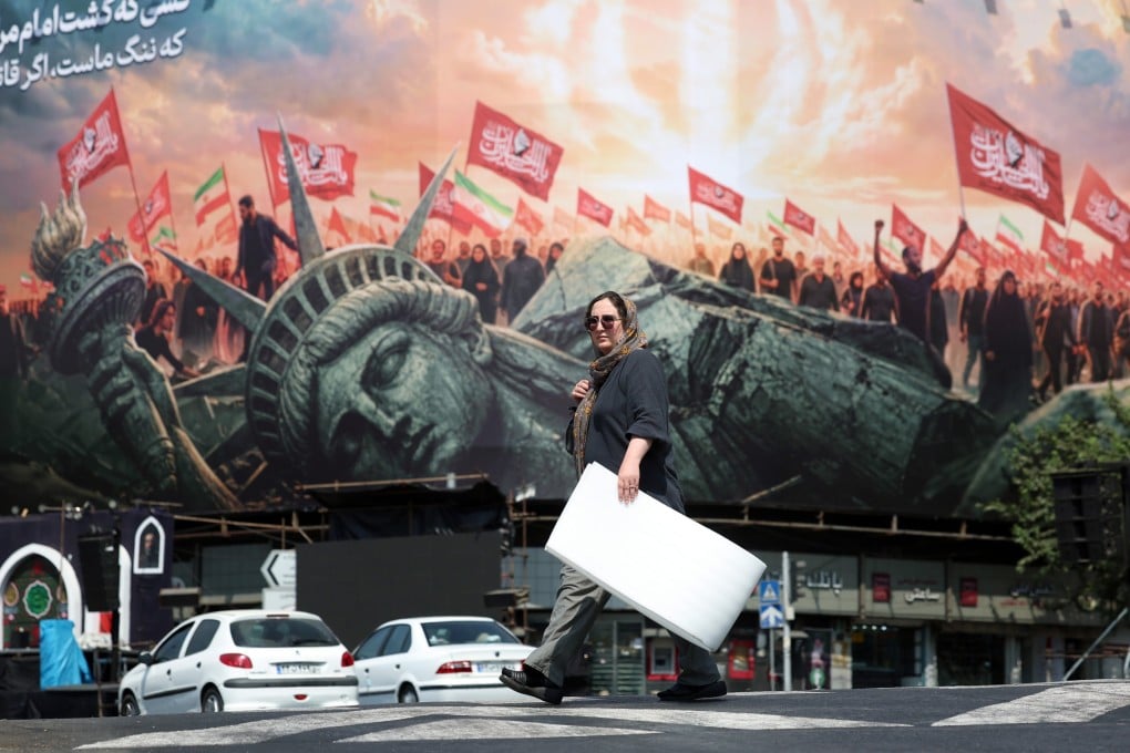 An Iranian woman walks next to an anti-US sign at Enghelab square in central Tehran, Iran on Thursday. Photo: EPA