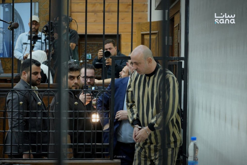 Wassim al-Assad is led into a defendant’s cage in the courtroom for his sentencing, at the Fourth Criminal Court in Damascus, on Tuesday. Photo: Syrian Arab News Agency / AFP