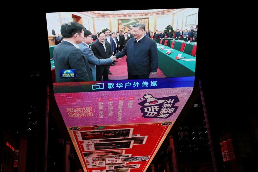 A giant screen shows news footage of Chinese President Xi Jinping shaking hands with DeepSeek founder Liang Wenfeng during a symposium on private enterprise, at a shopping complex in Beijing on February 17, 2025. China’s treatment of its billionaire class differs from the United States’. Photo: Reuters