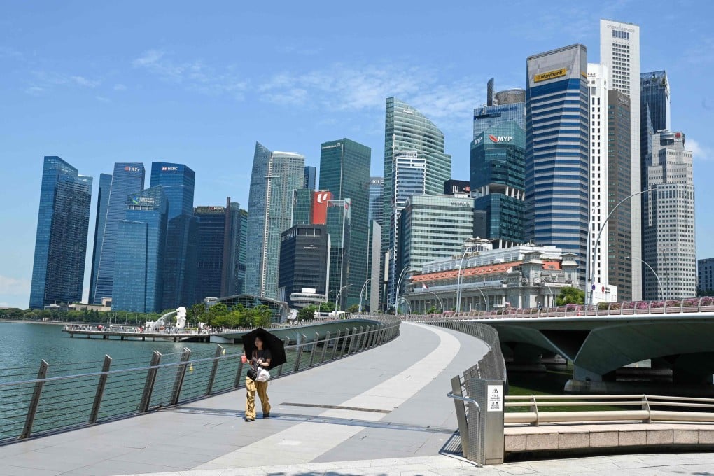 A woman walks past the financial business district high-rise buildings in Singapore in May. Photo: AFP