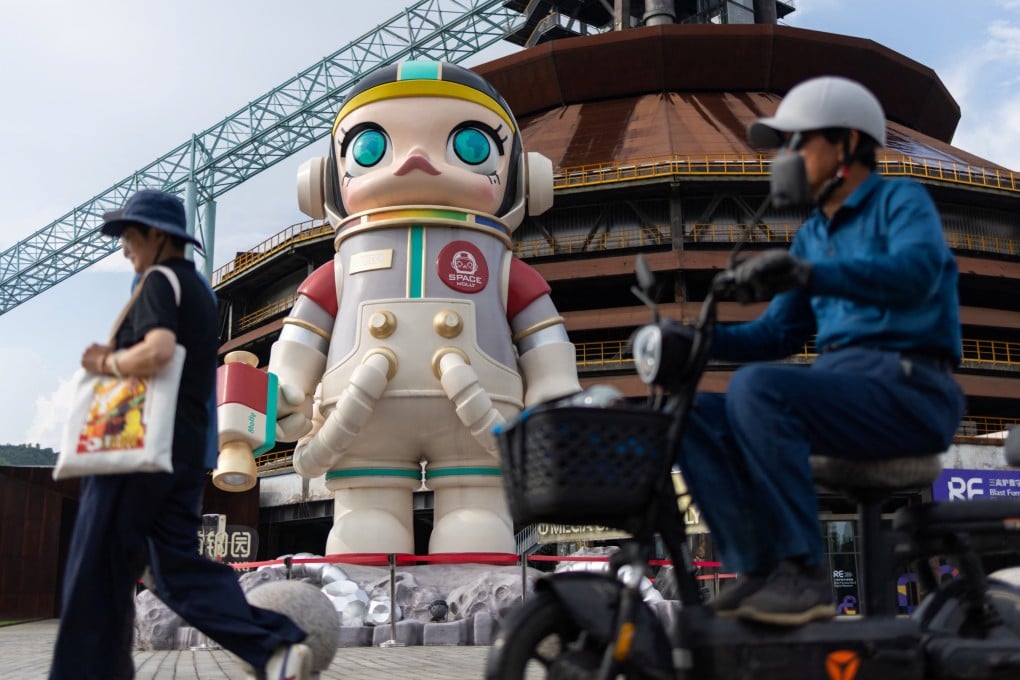 People pass by a giant figure of the Pop Mart character Space Molly in Beijing’s Shougang Park on August 7. Photo: Reuters