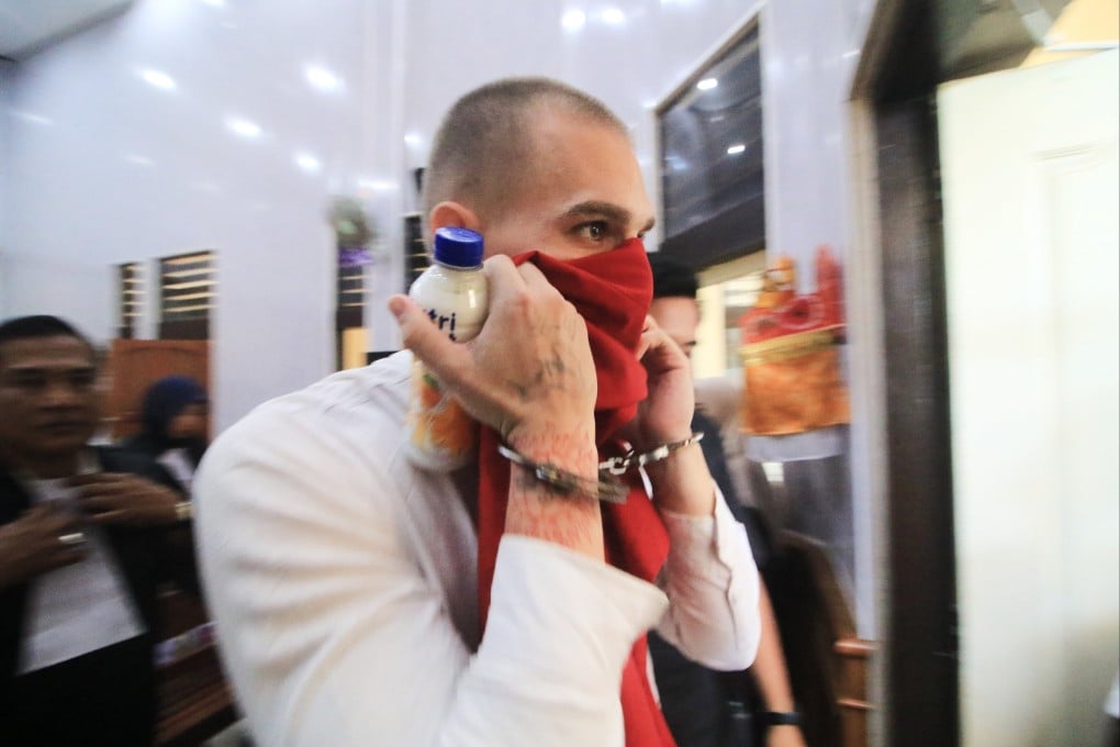 Swiss tourist Luzian Andrin Zgraggen covers his face as he leaves the courtroom after his sentencing hearing at the district court in Denpasar, Bali, Indonesia on Thursday. Photo: AP
