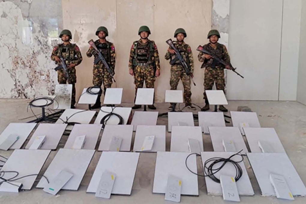 Members of Myanmar's military stand next to Starlink devices seized during a raid on an online scam centre in Kayin state last year. Photo: AFP