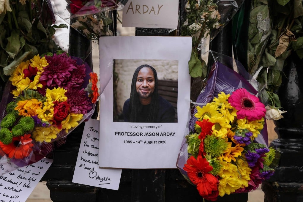 A photo of Jason Arday is surrounded with floral tributes, attached to the fencing by supporters around the Senate House at the University of Cambridge in England on Tuesday. Photo: AFP