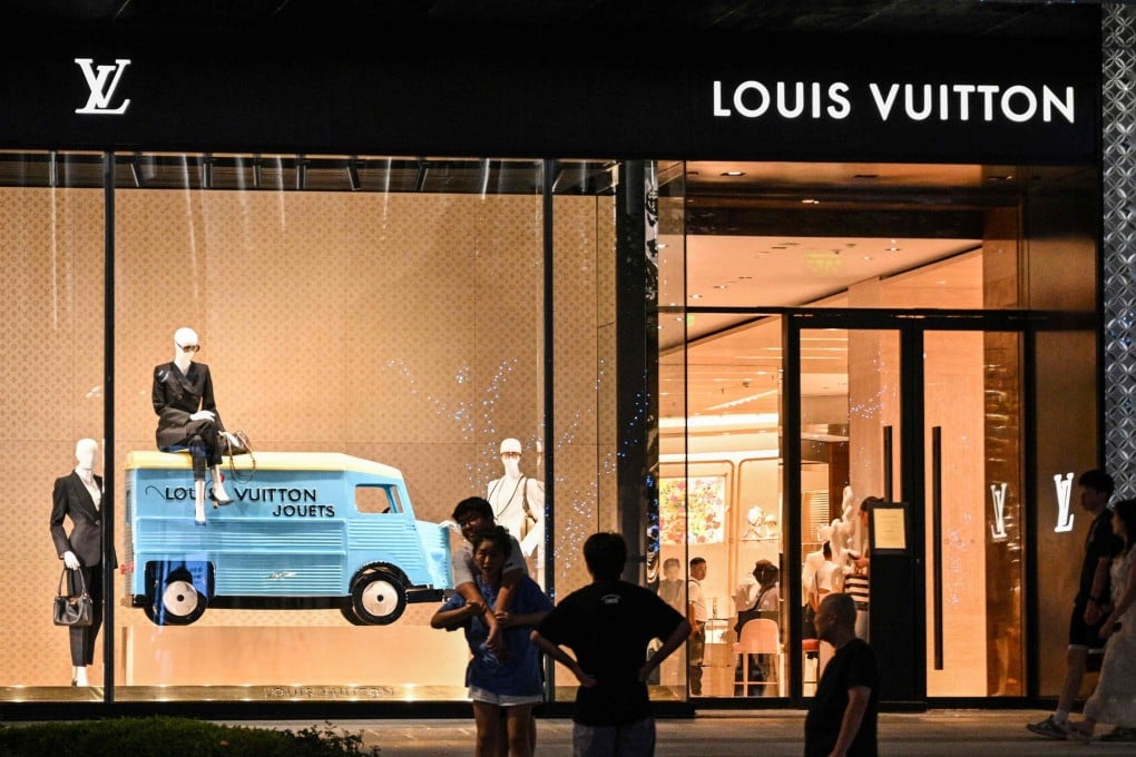 People walk next to a Louis Vuitton shop in Shanghai. Photo: AFP