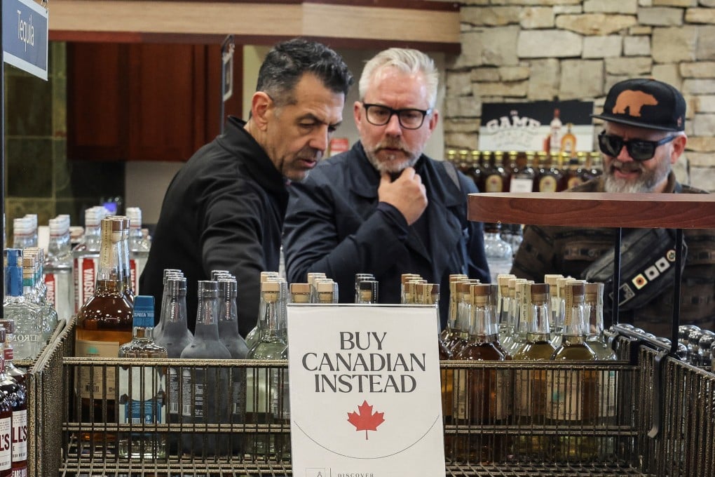 Shoppers stand by empty shelves with signs reading “Buy Canadian Instead” after the top five US liquor brands were removed from sale at a liquor store in Vancouver, Canada, as part of a response to US President Donald Trump’s tariffs on Canadian goods, on February 2, 2025. Photo: Reuters