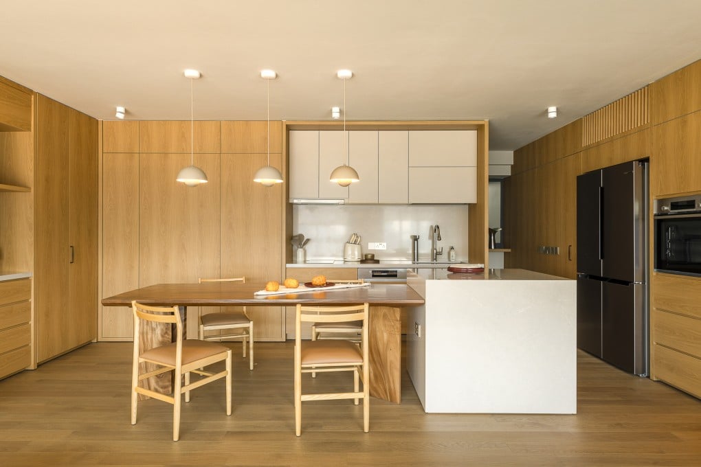The open kitchen of a flat in Pinnacle@Duxton, in Singapore, designed by Leena Interior Design Studio. The flat features layered design, oak finishes and minimalist tones. Photo: Kung Photograph
