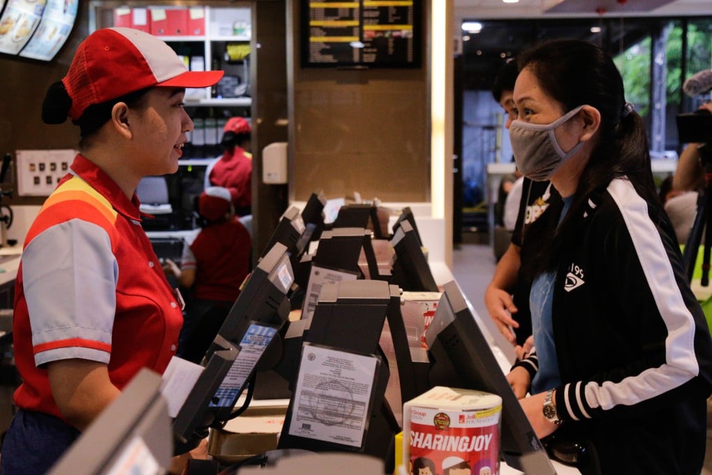 A Jollibee staff member takes orders from a customer at an outlet in Ortigas Center, Pasig City, Philippines, on May 27, 2019. Photo: Jansen Romero