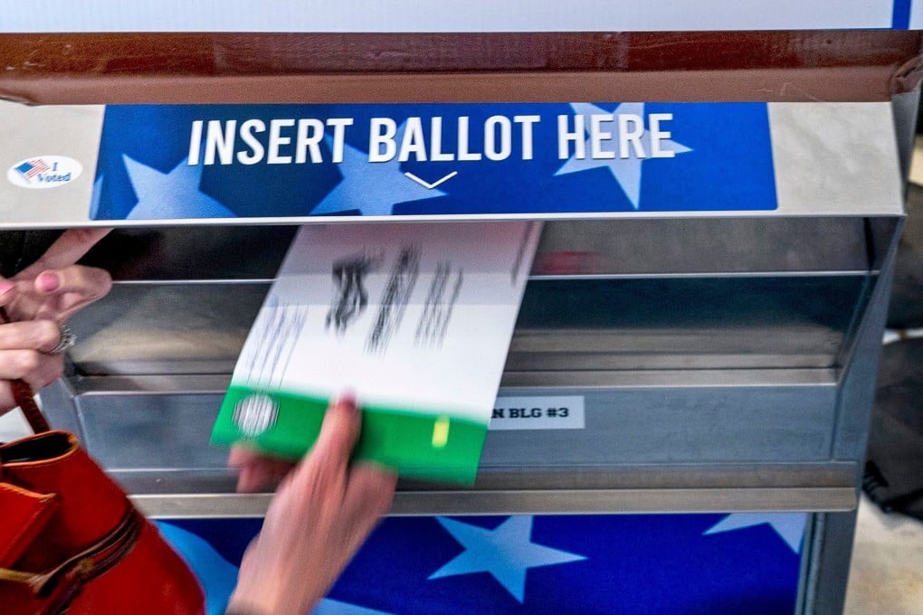 A voter places a mail ballot into a drop box. About 30 per cent of Americans vote by mail, according to state election data. Photo: TNS
