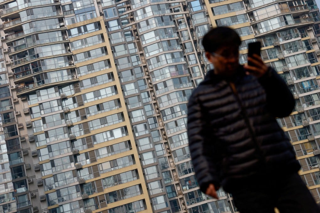 A man walks on an overpass near residential buildings in Beijing. Photo: Reuters