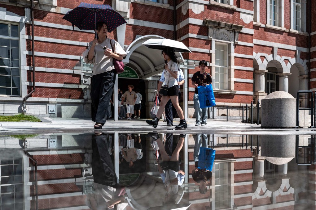 Commuters walk outside Tokyo Station on August 12. Photo: AFP