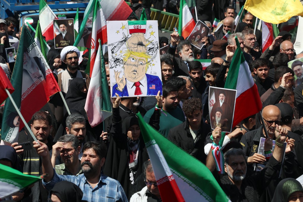 A woman holds a poster mocking US President Donald Trump during a rally in Tehran, Iran, in April. Photo: TNS