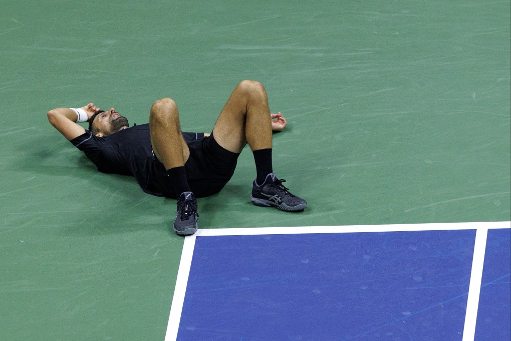 Novak Djokovic slumps to the floor during his US Open first round clash with Mariano Navone. Photo: EPA
