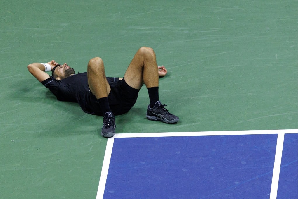 Novak Djokovic slumps to the floor during his US Open first round clash with Mariano Navone. Photo: EPA