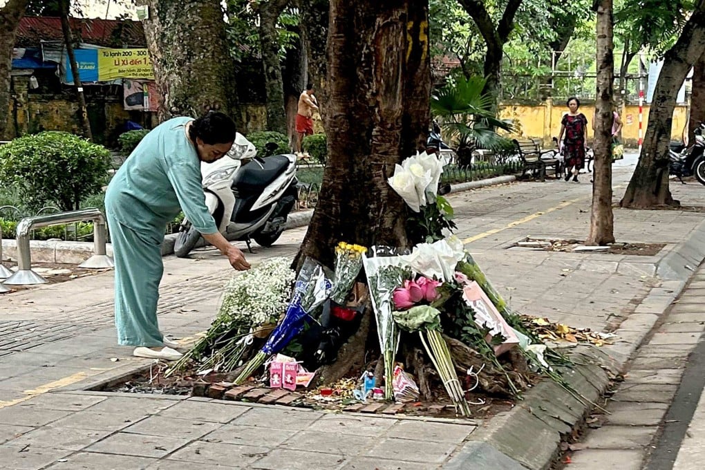 A woman looks at bouquets of flowers placed at the site of a traffic accident where a senior official had a fatal car crash in Hanoi on August 15. Photo: AFP