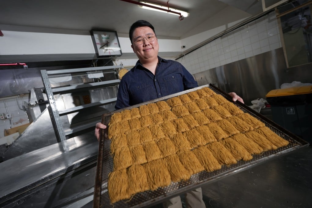 Wing Lok Noodle Factory’s second-generation director Angus Chan holds a tray of dried shrimp roe noodles at the company’s base of operations in Kowloon Bay, Hong Kong. The company, which celebrates its 50th anniversary in 2026, started as a relatively unknown noodle supplier, but has risen in recent years to become a well-known food brand in its own right. Photo: Sun Yeung