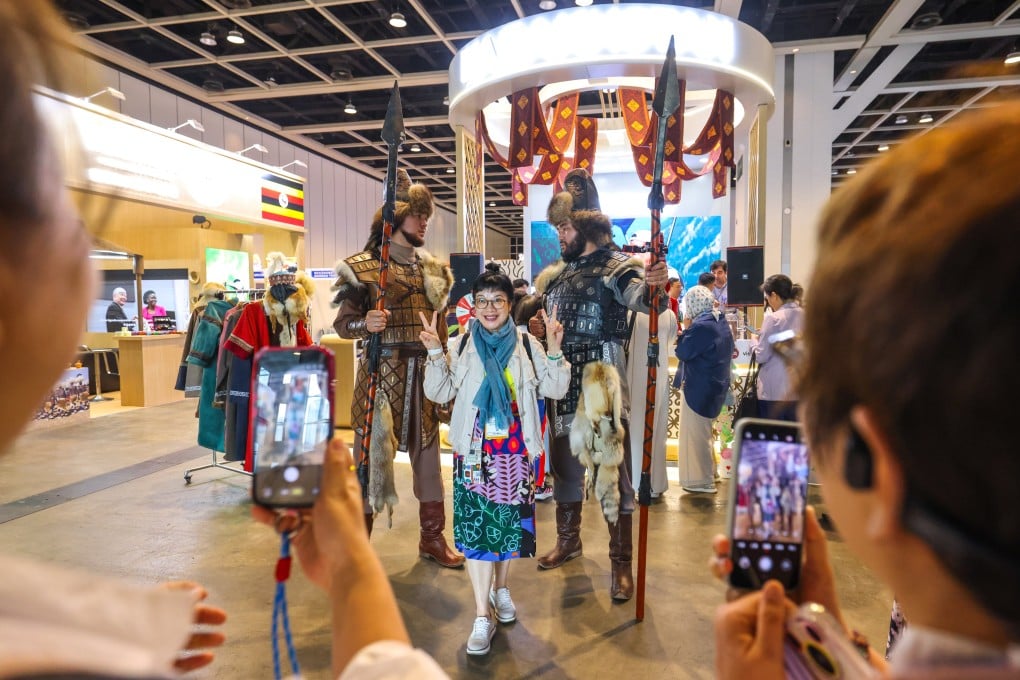 Visitors take pictures with 2-metre-tall promoters at Kazakhstan booth at Hong Kong’s International Travel Expo on June 11. The Belt and Road Office has concluded memorandums with key institutions in Central Asian countries like Kazakhstan, laying solid groundwork for collaboration. Photo: Nora Tam