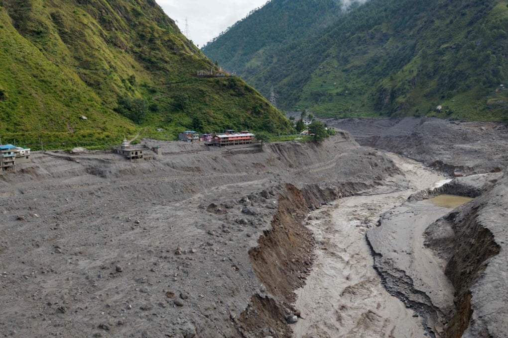A torrent of muddy water surges past houses and through the Trishuli River in the aftermath of flash floods, near the Nepal-China border at Syabrubesi village in Nepal’s Rasuwa district on August 31. Photo: AFP
