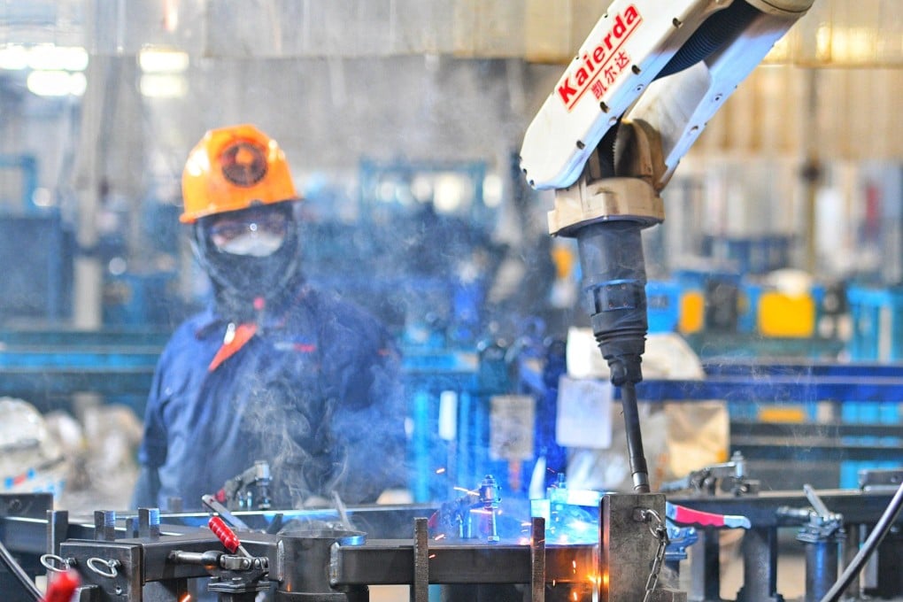 A worker operates a welding robot in Shandong province. Photo: Xinhua