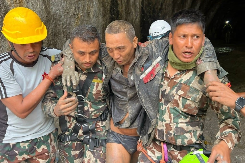 A Chinese man (second from right) was rescued from a tunnel in Nepal on Saturday, over a week after fatal flash floods devastated river valleys along the China-Nepal border. Photo: Army handout via EPA