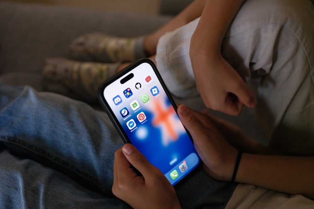 Children look at a phone screen with social media networking applcations displayed in December, in Sydney, Australia. Photo: Getty Images/TNS