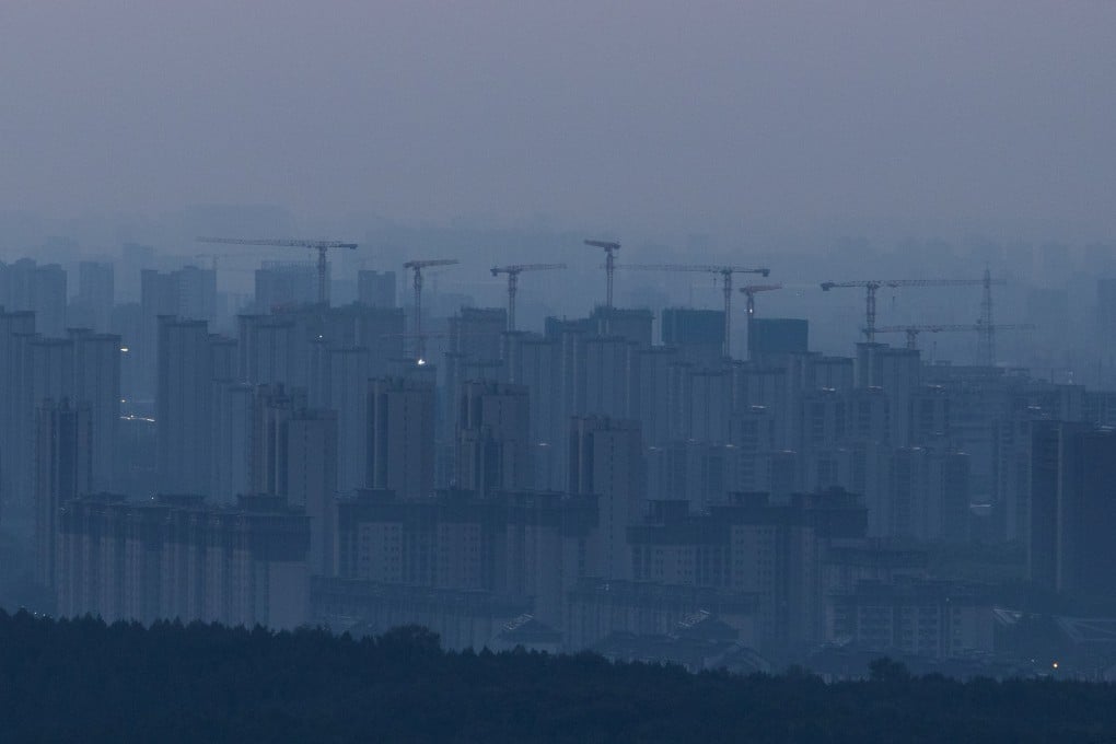 Construction cranes rise above a newly built residential district before sunrise in Beijing on September 3. Photo: Reuters