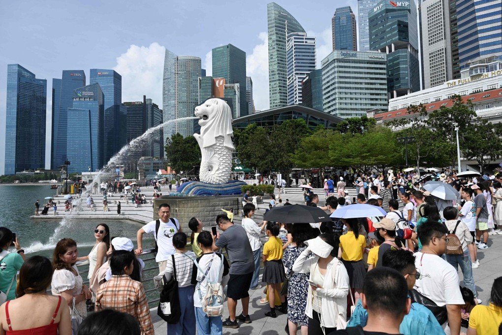 People gather near the Merlion statue at the Marina Bay Waterfront Promenade in Singapore in August 2024. Photo: AFP