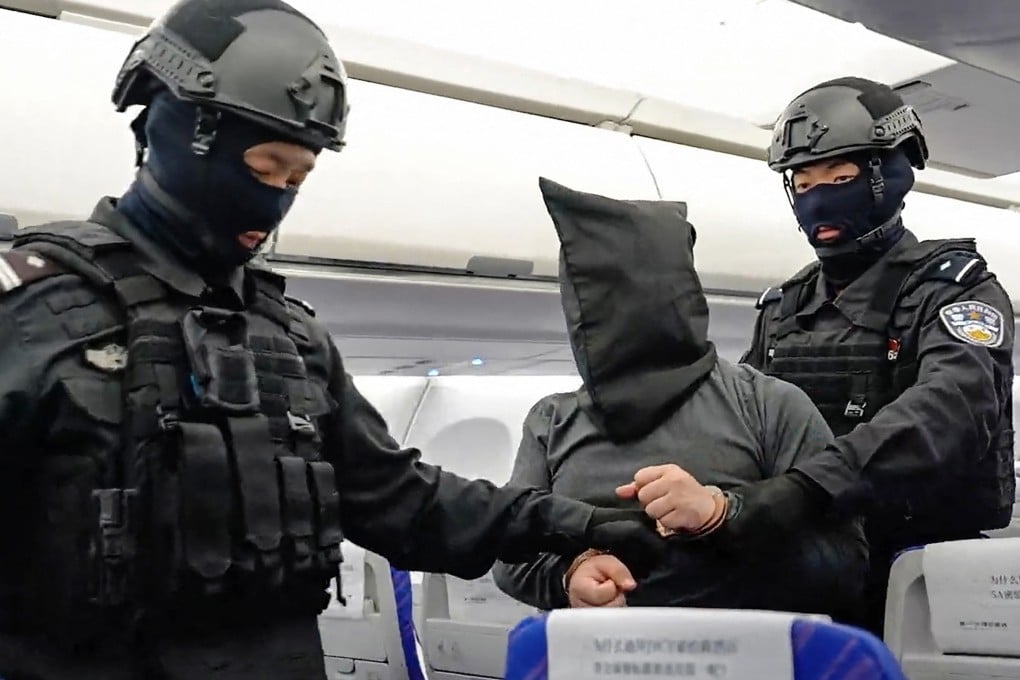 Chinese public security officers escort a suspected China-born scam boss off a plane after he was extradited from Cambodia in April. Photo: China’s Ministry of Public Security/AFP