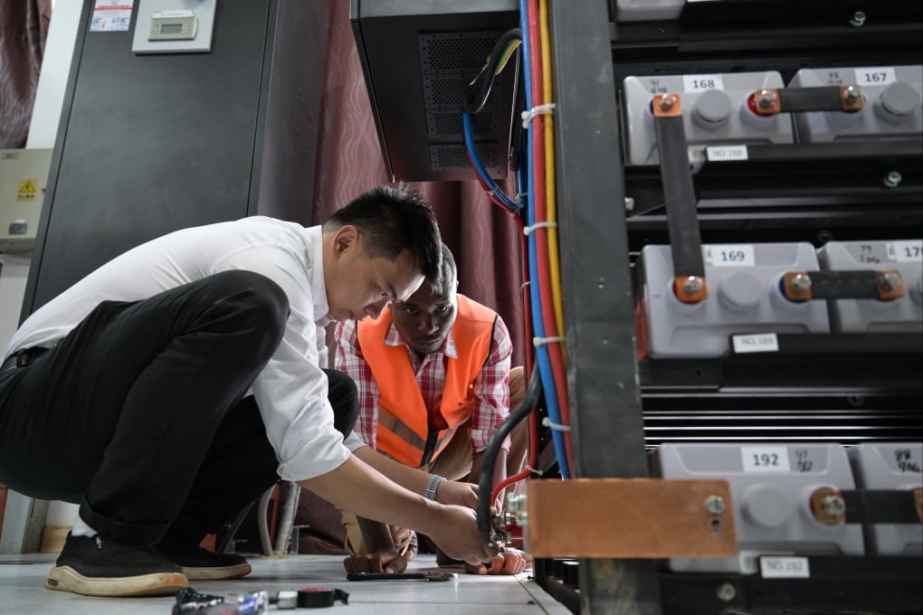 A Chinese communication engineer guides a Kenyan staff member on backup power replacement for the communication system at Mtito Andei station on the Mombasa-Nairobi Standard Gauge Railway in Kenya on July 23. The railway is part of China’s Belt and Road Initiaitve. Photo: Xinhua