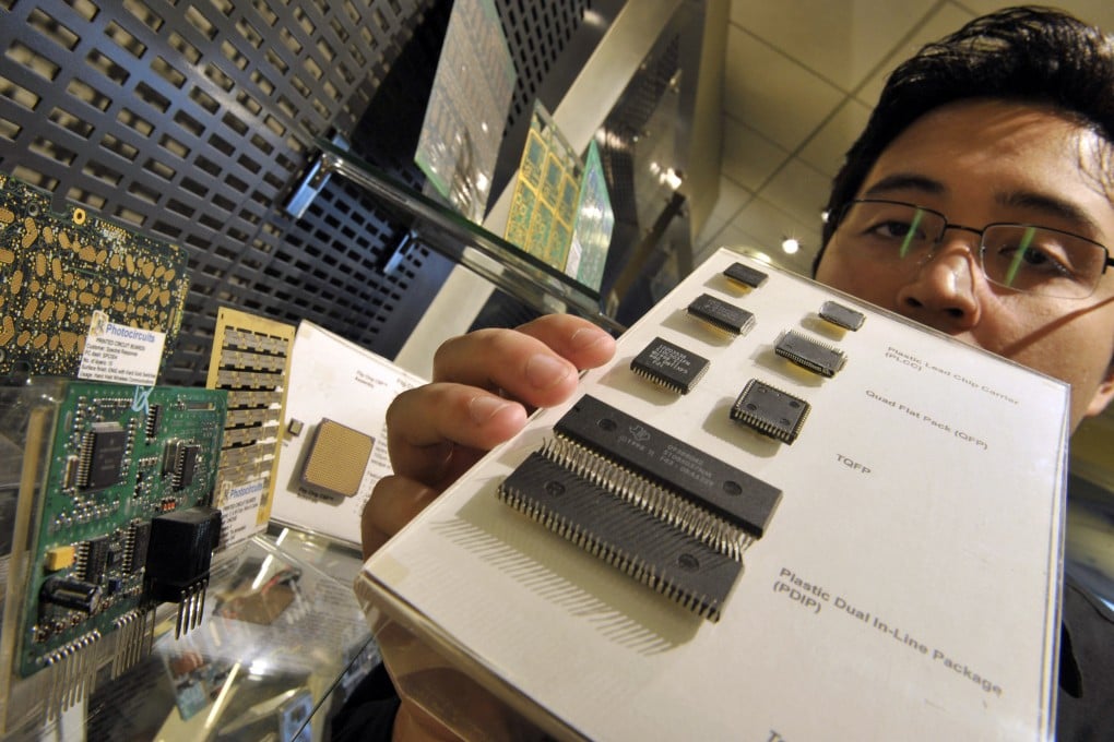 A staff of the Semiconductor and Electronics Industries in the Philippines shows chips manufactured in the country. Photo: AFP