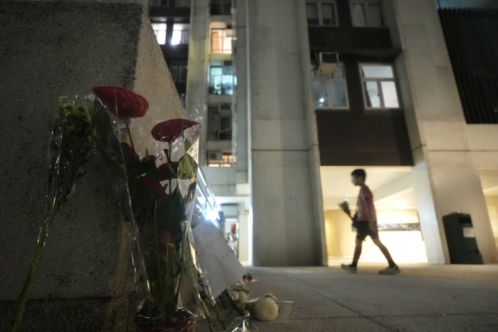 People lay flowers outside a building in Taikoo Shing, where a 48-year-old woman and her 12-year-old daughter fell from the same flat hours apart on June 10 after a reported argument over studies, raising concerns over the city's level of mental support. Photo: Sun Yeung