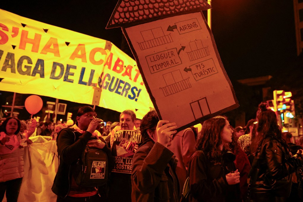 A person holds a sign that reads “from touristic flat to temporary rent to Airbnb” during a protest to demand lower housing rental prices and better living conditions, in Barcelona, Spain, in November 2024. Photo: Reuters