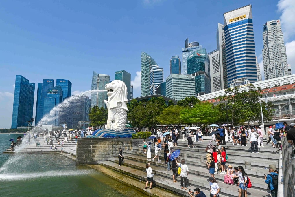 People take pictures next to the Merlion statue at the Marina Bay waterfront in Singapore in 2025. Photo: AFP
