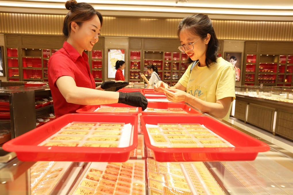 A customer selects gold ornaments at a jewellery shop in Hangzhou, Zhejiang province. Photo: Getty Images