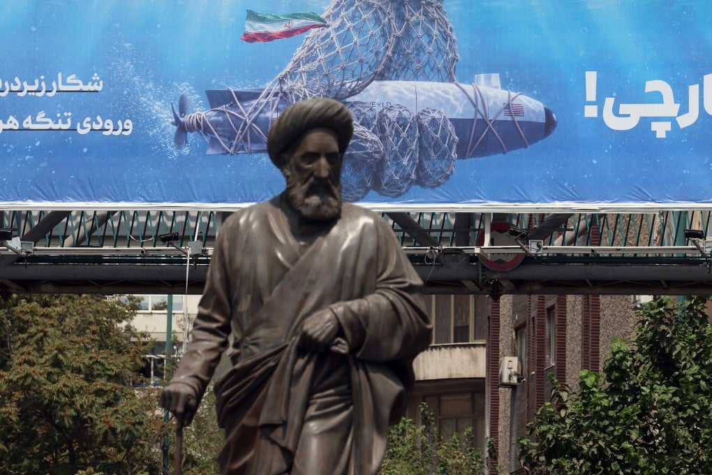 A statue stands in front of a billboard featuring a captured US underwater drone with text reading in Persian, ‘Hunting the Hunter’, in Tehran, Iran, on Wednesday. Photo: EPA