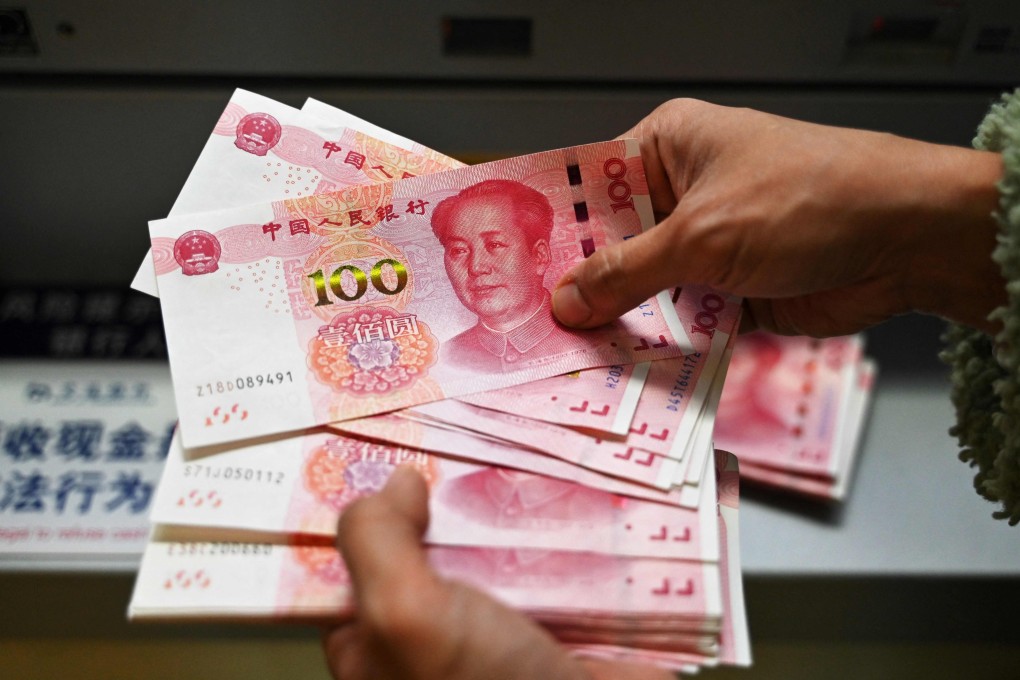 An employee counts 100-yuan notes at a bank in Beijing in November 2024. Photo: AFP