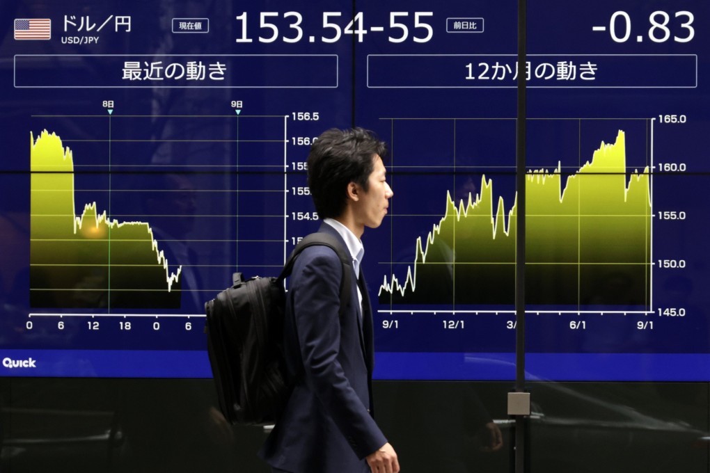 A passerby walks in front of a monitor showing the foreign exchange rate between the US dollar and the Japanese yen in Tokyo. Photo: EPA