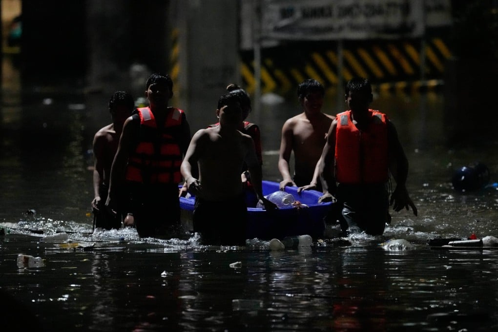 Men push a small boat along a flooded street after intense monsoon rains in Quezon City, the Philippines, last month. Photo: AP