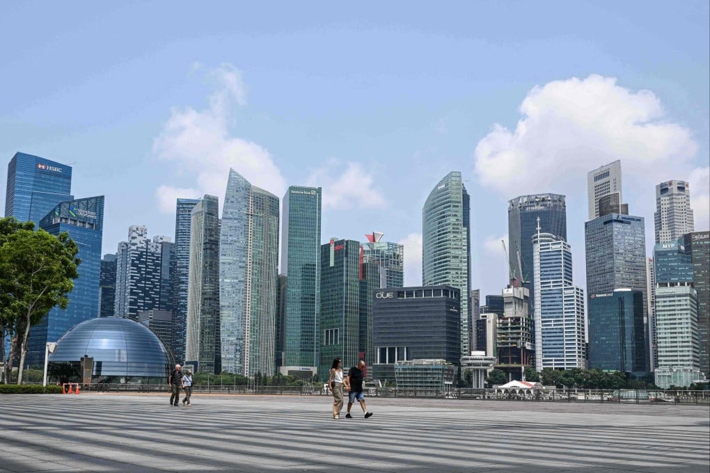 People walk along the promenade next to Marina Bay in Singapore on Tuesday. Photo: AFP